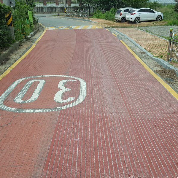 학교 앞 30km/h 제한 구간의 적색 미끄럼 방지 포장 위에 시공된 종방향 그루빙